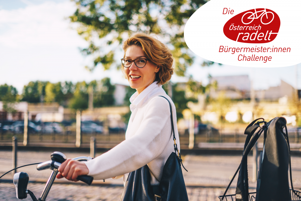 Frau blickt lachend mit ihrem Fahrrad in die Kamera.