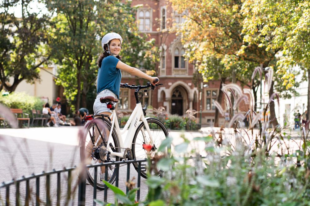 Frau schiebt Gerro E-Bike vor Kirche und schaut nach hinten in die Kamera